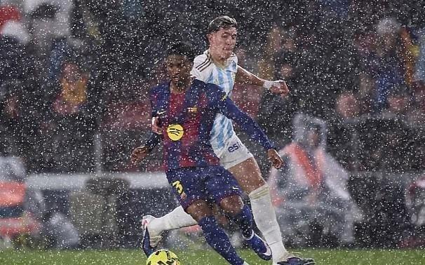 暴雨倾泻进诺坎普球场，记者纷纷在媒体席上撑起雨伞工作