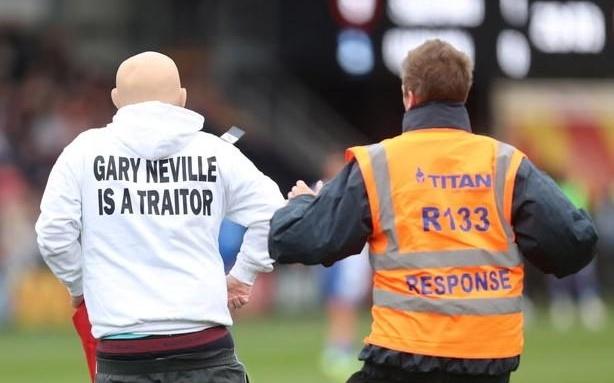 两男子穿着印有“加里内维尔是叛徒”的衣服,冲入英乙赛场